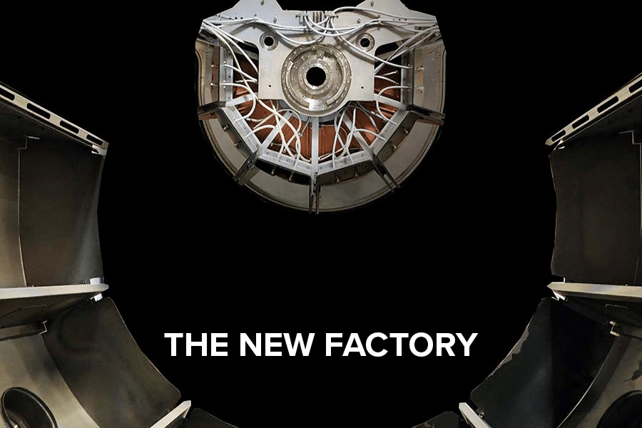 Close-up of a sputter machine. White text with "The new factory".