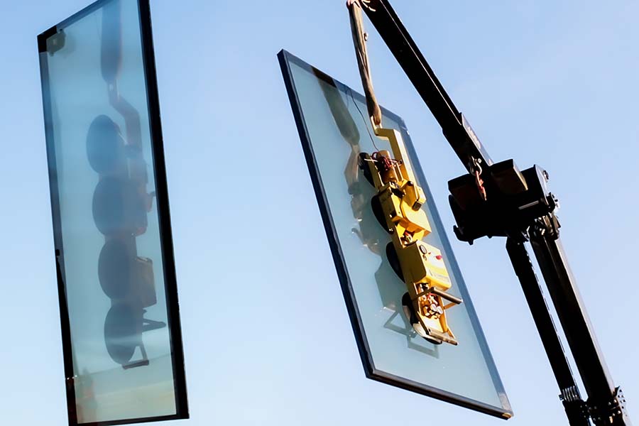 Crane carries dynamic glass on a sunny day.