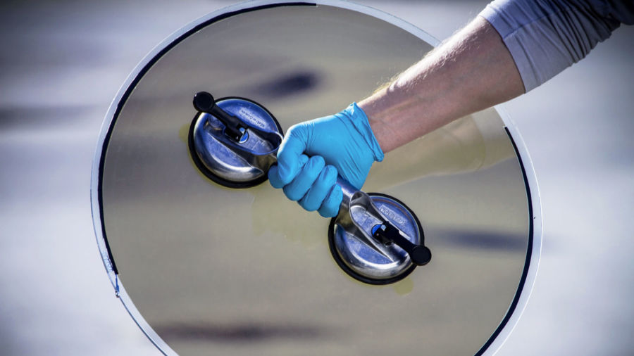 chromogenics-2018-04-17-2-3-2-redigerad-900x506 Hand with a light blue glove holding a round glass outside.